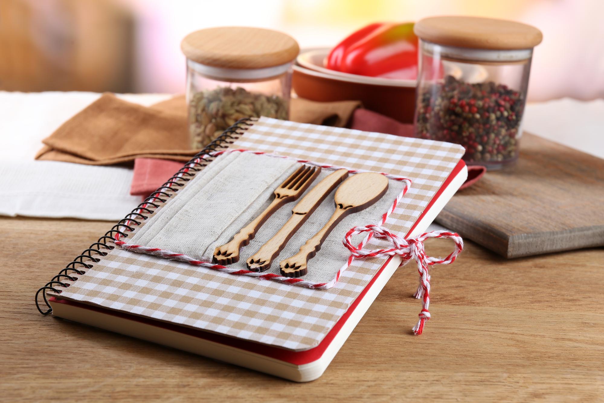 notebook and tasting spoons on paper surface